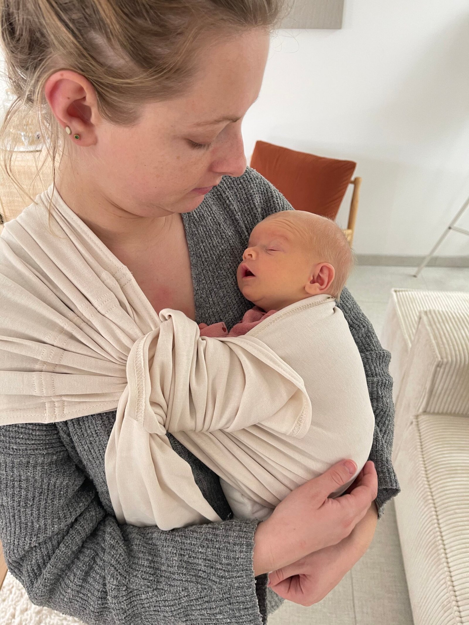 Maman portant son bébé en sling clair